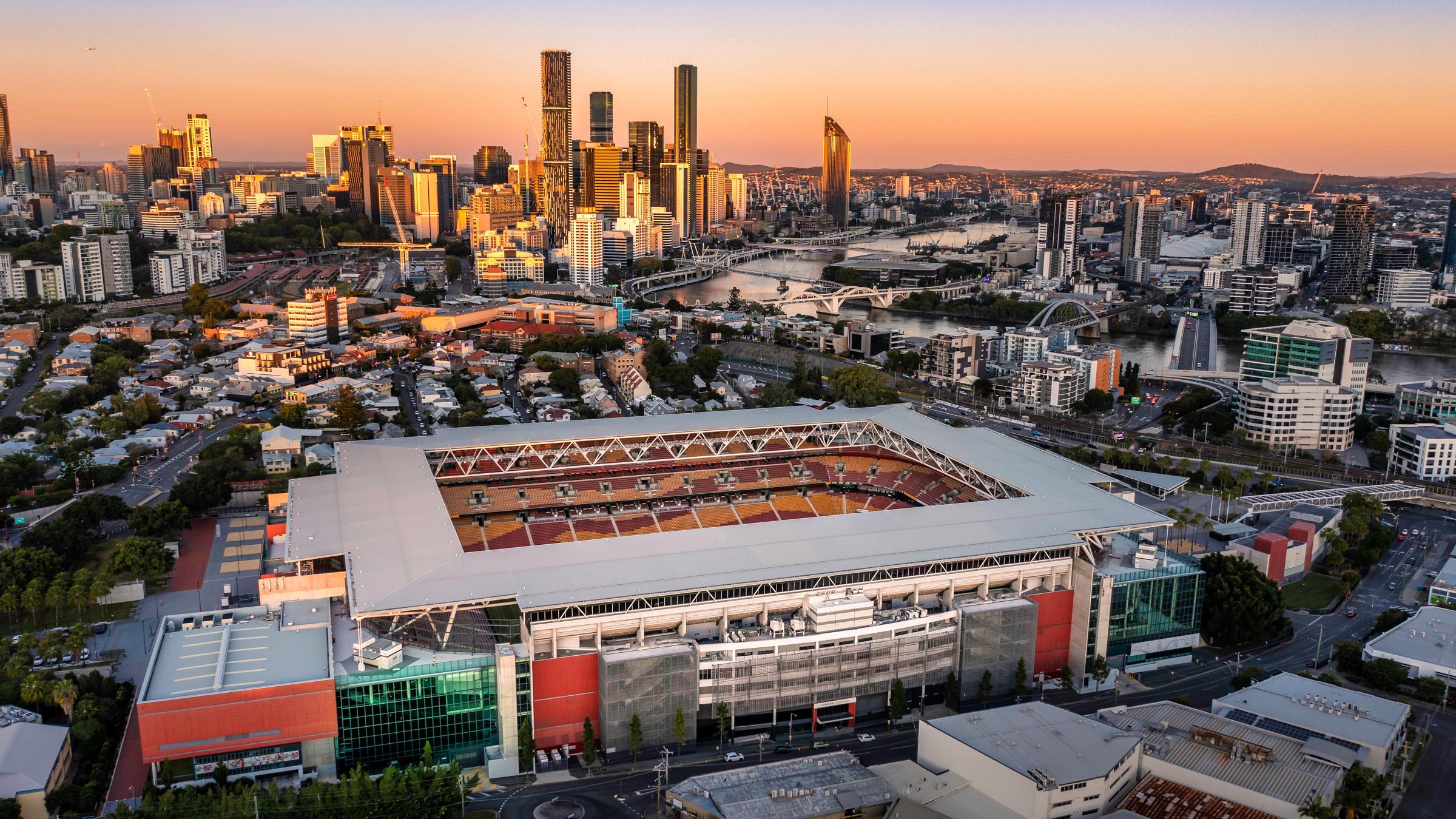 Aerial shot of Suncorp Stadium at sunset, with Brisbane City in the background