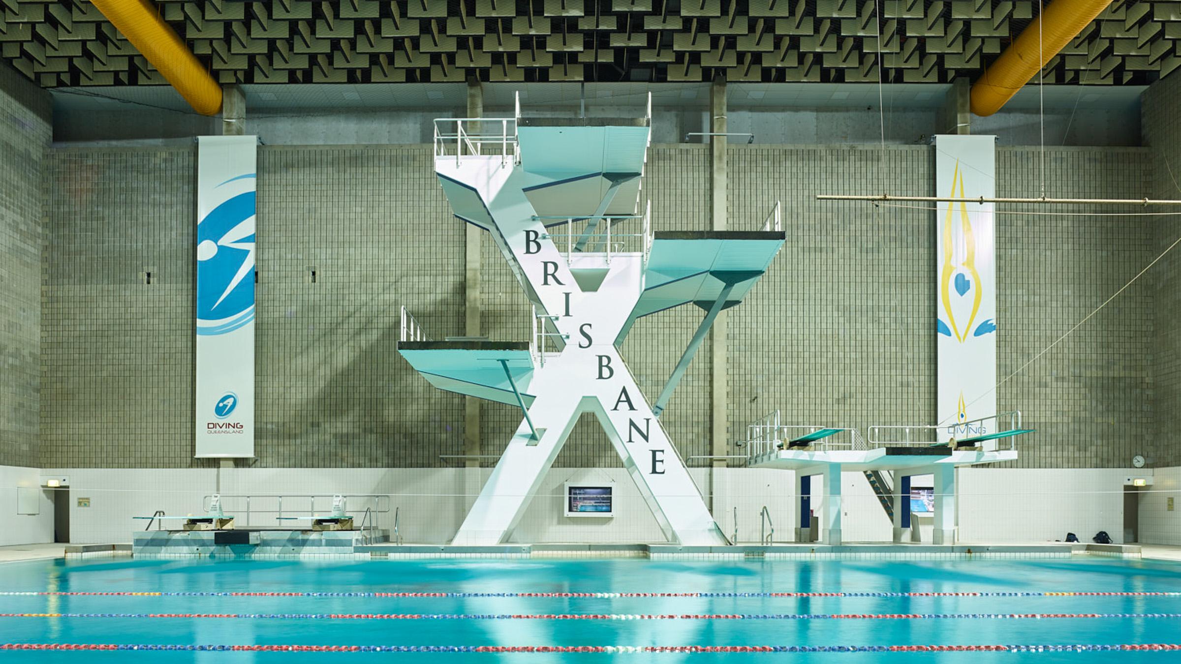 Indoor view of Brisbane Aquatic Centre featuring multiple diving platforms at various heights over the pool