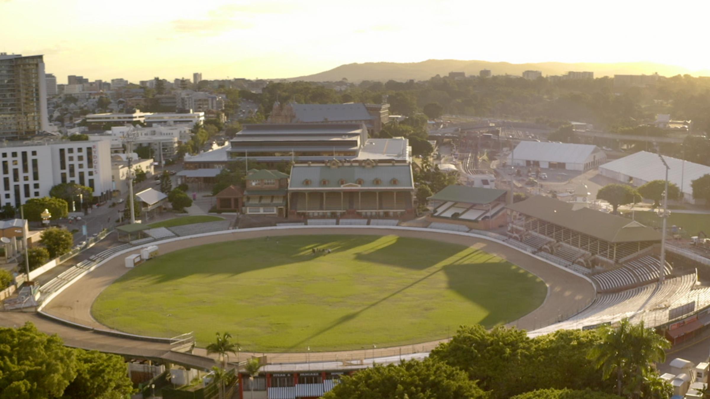 Aerial view of Brisbane Showgrounds oval and exhibition hall at sunset