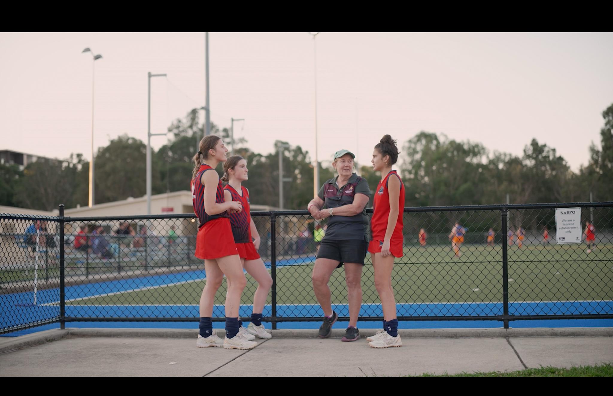 Hockey Queensland volunteer Lyn Hill with Panthers Hockey Club athletes