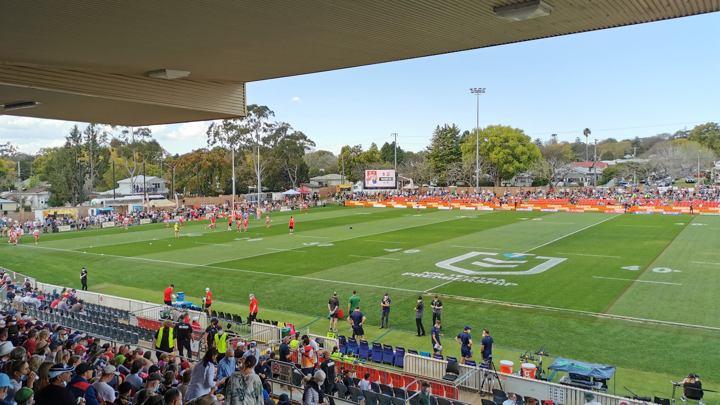 Stadium view of the Toowoomba sports ground, with athletes on the field playing a rugby match