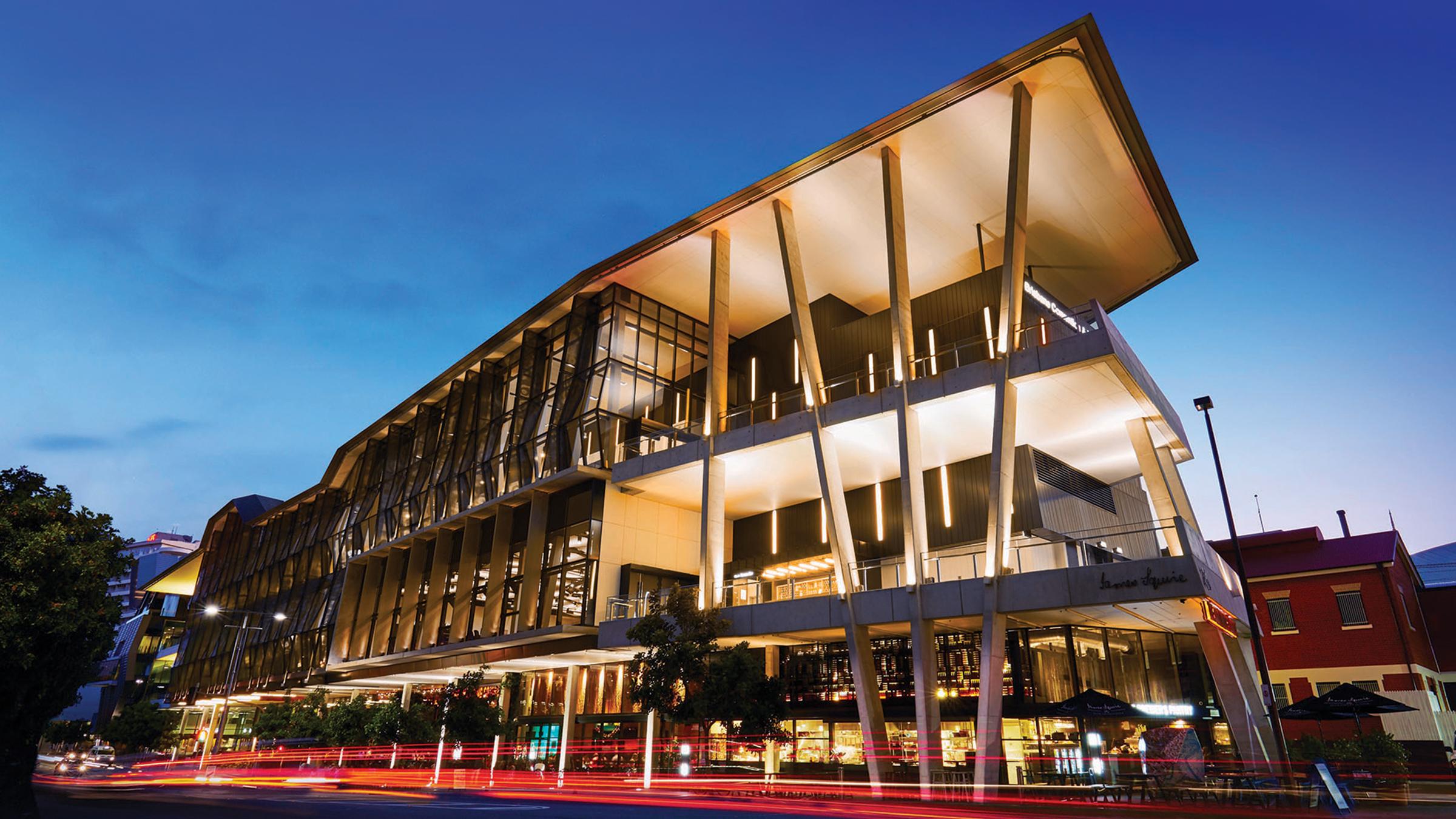 Street-facing facade of the Brisbane Convention and Exhibition Centre lit up at night