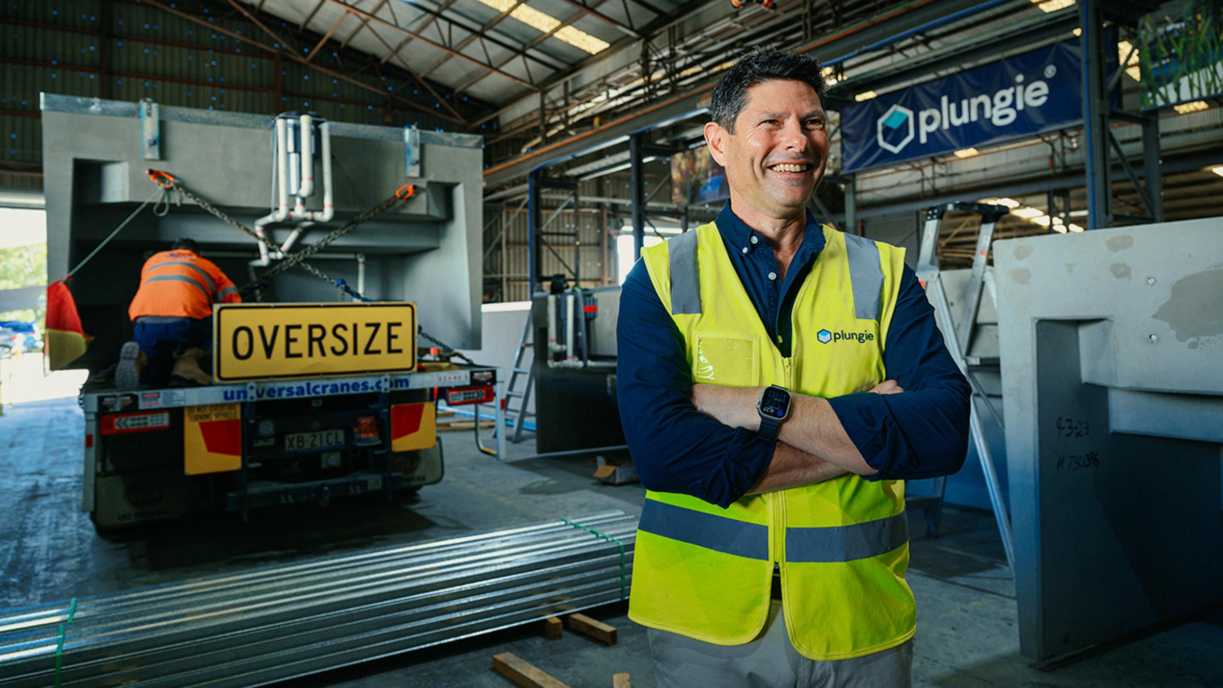 Smiling man wearing high-vis in a warehouse