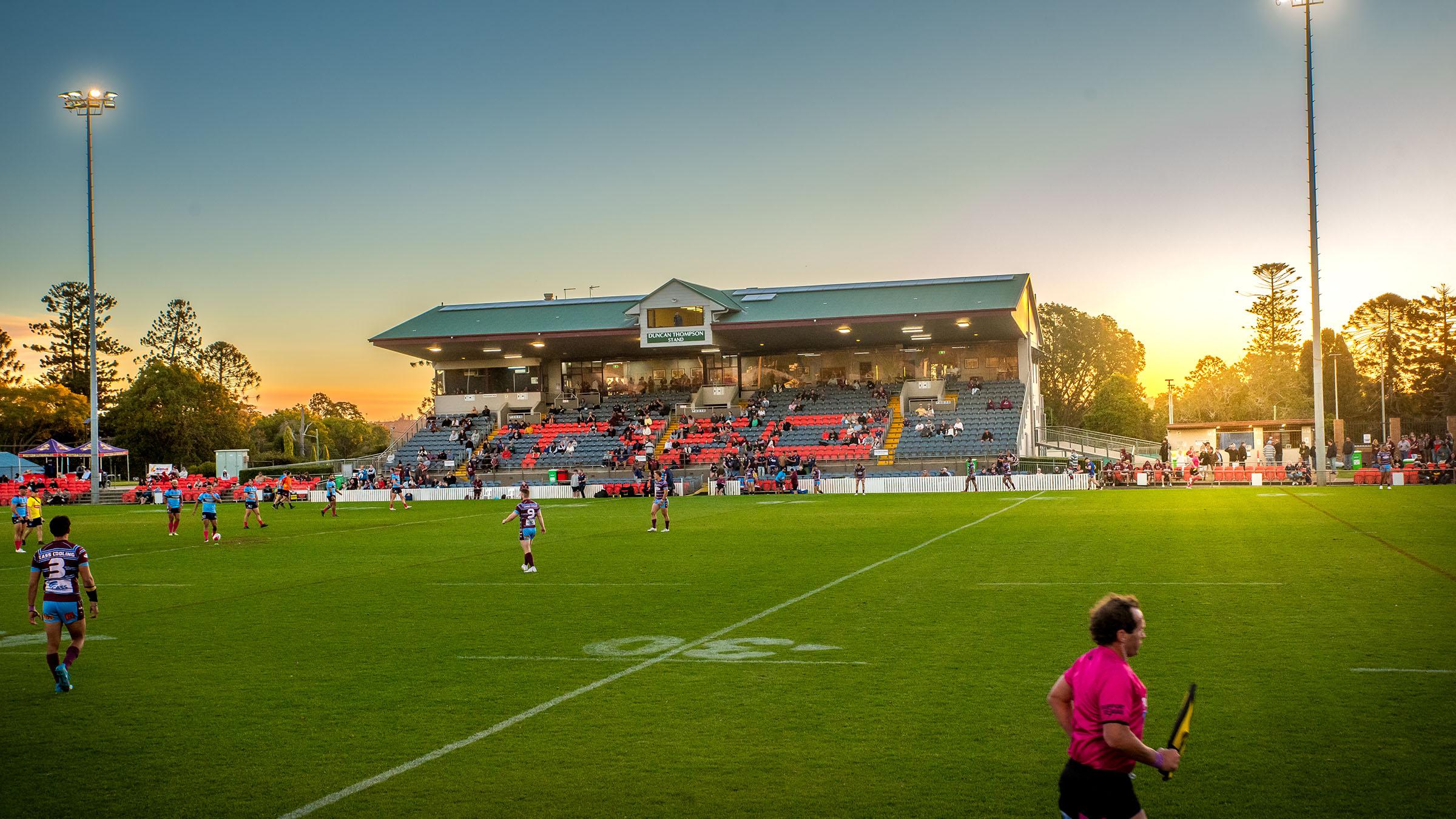 Stadium view of the Toowoomba sports ground, with athletes on the field playing a rugby match
