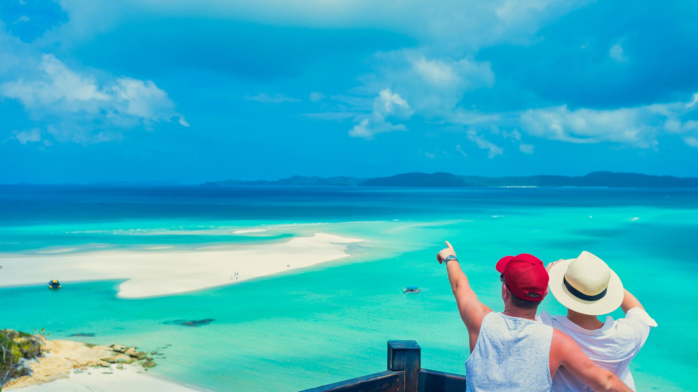 Couple viewing Whitehaven beach from a lookout, in the Whitsunday Islands Queensland.
